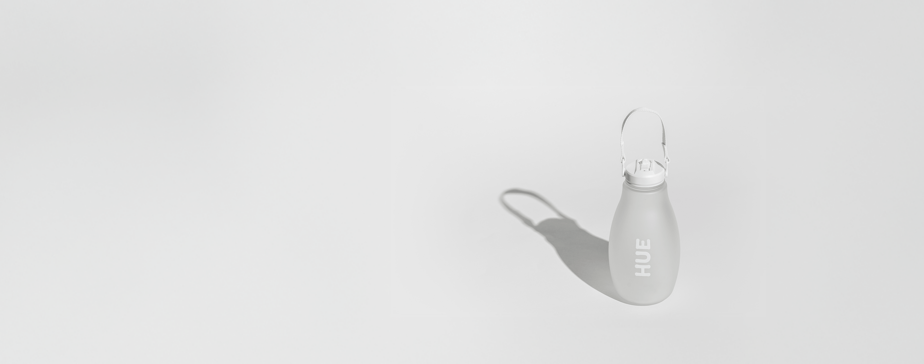 White water bottle labelled HUE with a strap on a light gray background